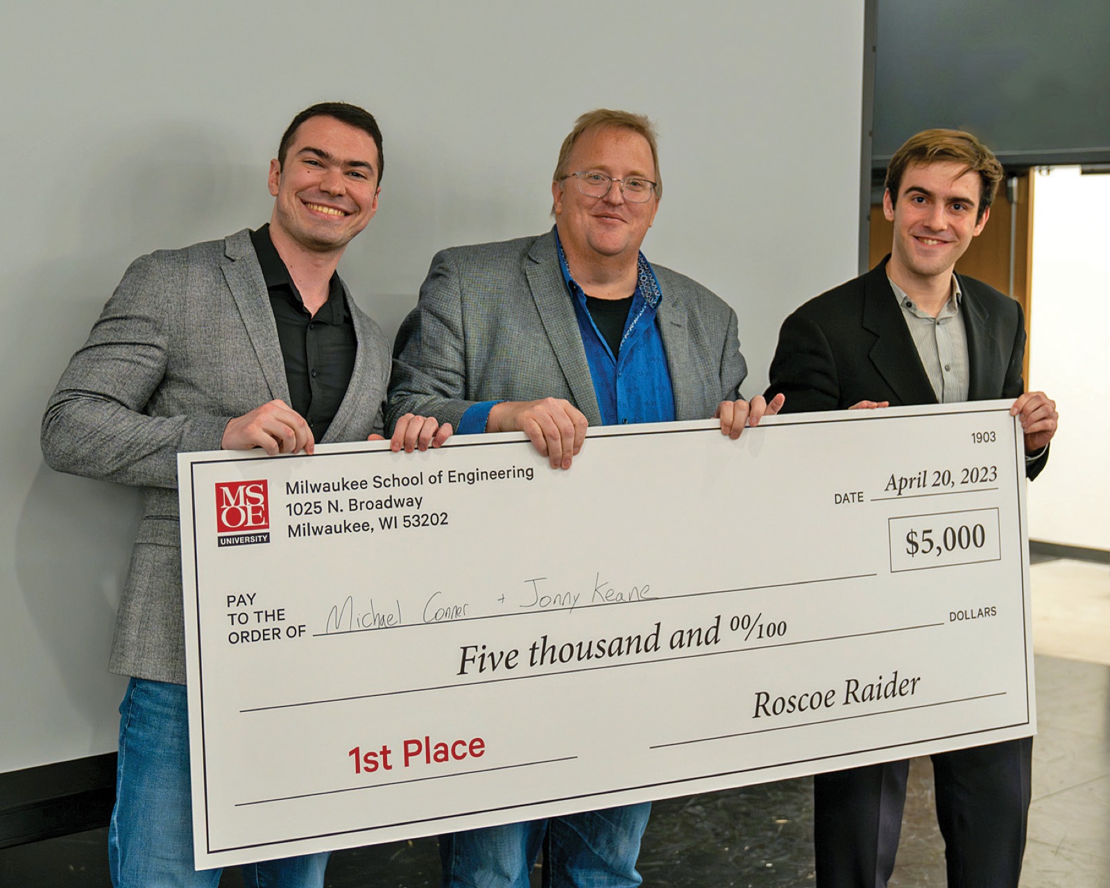 MAIC student receiving the $5,000 first-place check at the ROSIE Awards, presented by Dwight Diercks